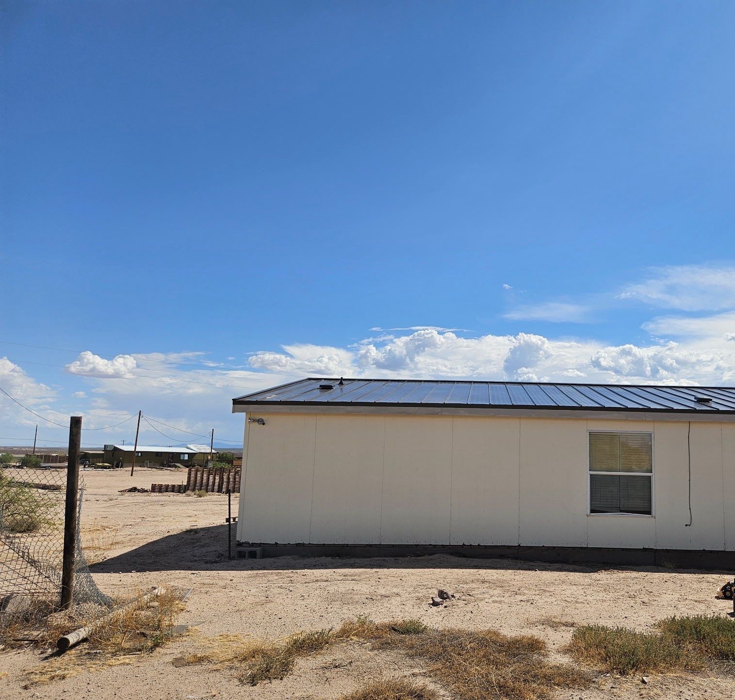 New dark charcoal standing-seam metal roof on a home in Safford, Arizona